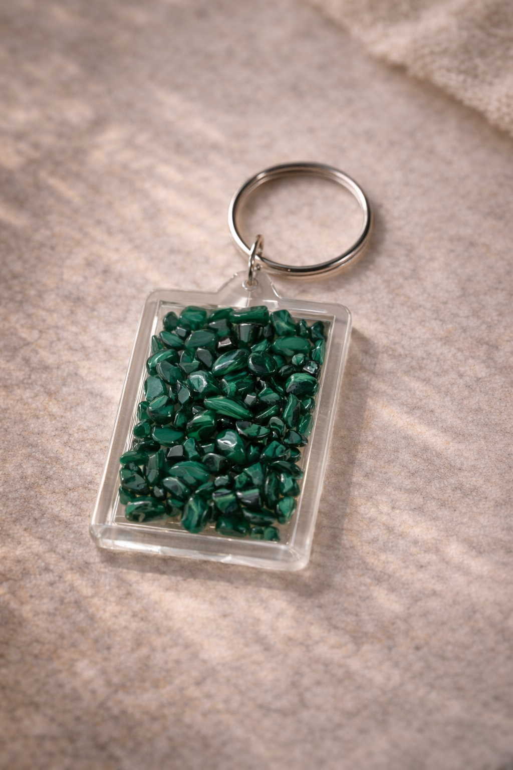 Pocket Energy Keyring filled with malachite crystal chips for protection and transformation.