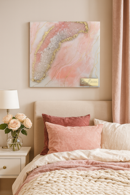 Rose quartz geode resin artwork with gold foil detail hung above a luxury feminine bedroom bed.